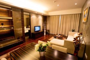 sala de estar con sofá y TV en SLD-Yicen INTERNATIONAL SERVICE APARTMENT, en Guangzhou