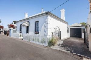 a white house with a white fence at Thyme Cottage Warrnambool in Warrnambool