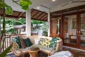 a patio with a couch and chairs on a porch at The Secret Karimunjawa in Karimunjawa