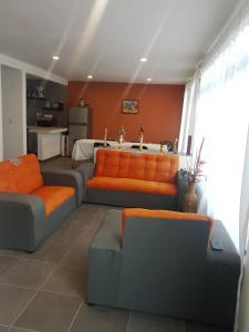 sala de estar con 2 sofás y almohadas de color naranja en La morada naranja Tepotzotlán, en Tepotzotlán