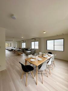 a dining room with a table and chairs and a couch at bHOTEL Kaniwasou 201 2BR Apt, Near Itsukushima Shrine, For 12 Ppl in Hatsukaichi