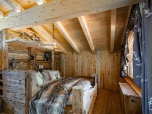 una camera da letto in una baita di tronchi con un grande letto di Lush holiday home with sauna a Grän