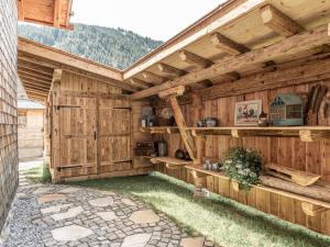 um edifício de madeira com um pátio com um telhado em Lush holiday home with sauna em Grän