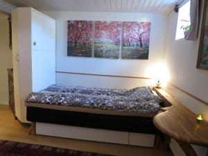 een klein bed in een kamer met 2 ramen bij Unique homestay in Huddinge