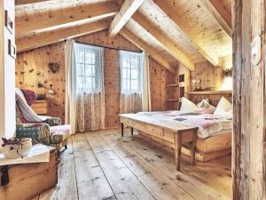 a bedroom with a bed and a wooden ceiling at Rustic holiday home with sauna in Grän