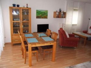 jadalnia z drewnianym stołem i krzesłami w obiekcie Holiday apartment with a garden w mieście Horumersiel