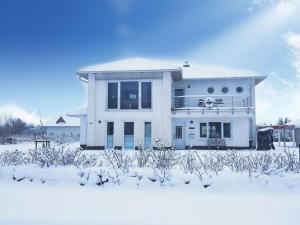 a white house with snow on the ground at To"n Lüchtfüer Comfortable holiday residence in Dwarsdorf