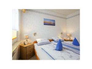 a bedroom with two beds with blue pillows at Holiday home - Beckmann-Visser 3 in Borkum