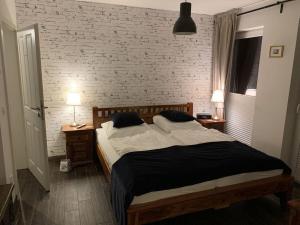 a bedroom with a bed and a brick wall at To"n Lüchtfüer Comfortable holiday residence in Dwarsdorf