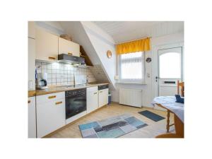 a kitchen with white cabinets and a stove top oven at Holiday home - Beckmann-Visser 3 in Borkum