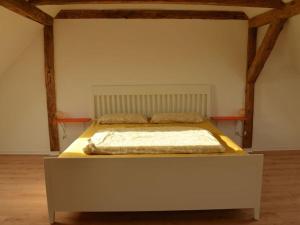 uma cama grande num quarto com vigas de madeira em Clay house with sauna em Tangermünde