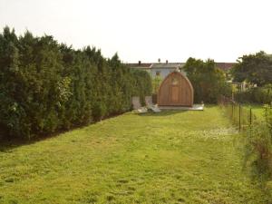 um jardim com duas cadeiras e um barracão em Clay house with sauna em Tangermünde