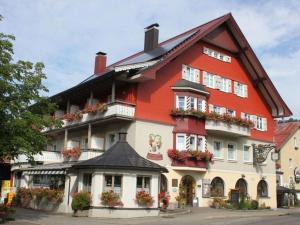 a large red and white building with flower boxes at Kreuzwiesen Modern retreat in Missen-Wilhams