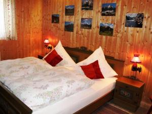 a bedroom with a bed with red and white pillows at Kreuzwiesen Modern retreat in Missen-Wilhams