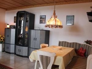 ein Esszimmer mit einem Tisch und einem Kronleuchter in der Unterkunft Kreuzwiesen Modern retreat in Missen-Wilhams