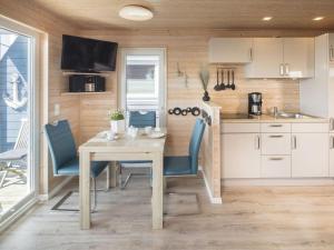 a kitchen and dining room with a table and chairs at Premium houseboat on the lake in Burgstaaken