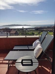 a bench on a balcony with a view of the ocean at Cambados Apartamento VUT-PO-TU986D in Cambados