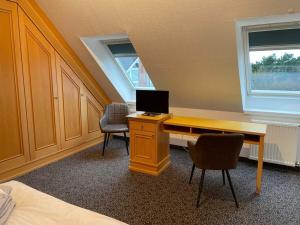 a room with a desk with a computer and two chairs at Nice holiday home with terrace in Juist