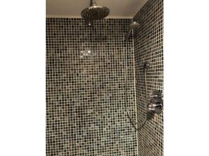 ein Bad mit einer Dusche mit schwarzen Fliesen in der Unterkunft Holiday apartment oasis 