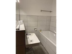 een badkamer met een wastafel en een bad bij Wingertsblick Modern retreat in Graach