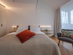 ein Schlafzimmer mit einem Bett mit einem roten Kissen darauf in der Unterkunft Suite apartment 80 sqm in Gundholzen