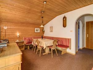 a dining room with a table and red chairs at Spacious holiday home with balcony in Carezza al Lago