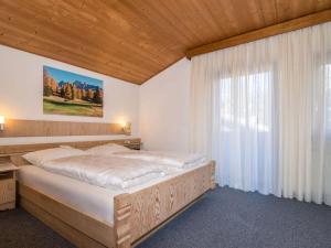 sypialnia z dużym łóżkiem i oknem w obiekcie Spacious holiday home with balcony w mieście Carezza al Lago