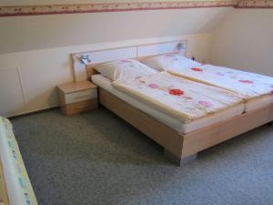een slaapkamer met een bed en een nachtkastje bij Rose ambience Modern retreat in Bad Langensalza