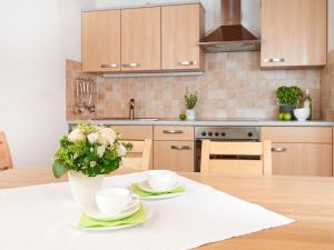 a kitchen with a table with a vase of flowers at Oberstdorf dream view - Alpine star in Oberstdorf