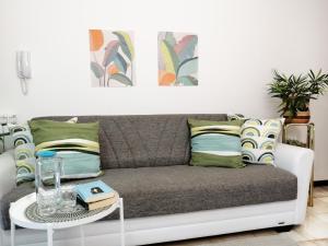 a living room with a couch and a table at HoliHome_La Sirena 50m dal Mare in Tortoreto Lido +14 photos