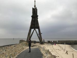 a man standing in front of a wooden tower on the beach at Nice holiday home near the centre in Duhnen