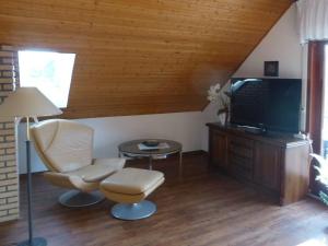 a living room with a chair and a flat screen tv at "Weserbergland" Modern retreat in Beverungen