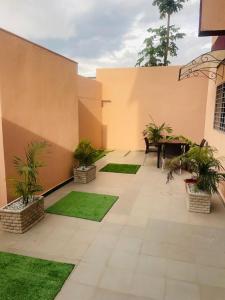 un patio con césped y plantas en un edificio en RESIDENCE MH SERVICES Abidjan en Abiyán