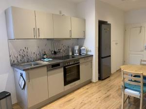 a kitchen with white cabinets and a wooden table and a tableablish at Amazing holiday home near the lake in Hambühren