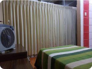 Un dormitorio con una cama verde y blanca y una ventana en The Nasca Sunshine, en Nazca