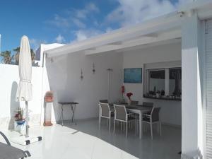 a dining area with a table and chairs on a patio at Holiday home with a roofed terrace in Morro del Jable