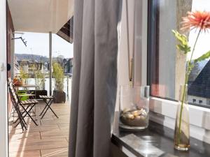 Un balcón con una mesa con un jarrón y una ventana en FeWo Freiken 28 Modern retreat en Arnsberg