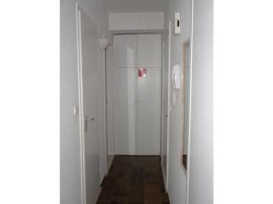 a hallway with white walls and a white door at Noordpas Comfortable holiday residence in Koksijde