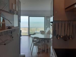 a dining room with a table and a view of the ocean at Noordpas Comfortable holiday residence in Koksijde +10 photos