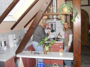 Due donne in piedi in una cucina a preparare il cibo di in the Oertel holiday home 