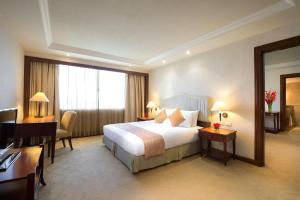 a hotel room with a bed and a desk and a computer at Marco Polo Plaza Cebu in Cebu City