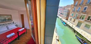 a bedroom with a view of a river from a window at Hotel Messner in Venice