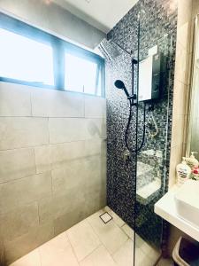 a bathroom with a shower with a glass door at The Shore by MD Staycation in Kota Kinabalu