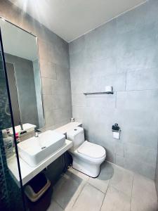 a bathroom with a white toilet and a sink at The Shore by MD Staycation in Kota Kinabalu