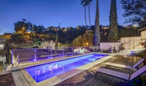a swimming pool with two benches next to at Happy party house in Los Angeles