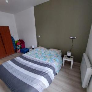a small bedroom with a bed and a table at résidence Les hortensias L4 in Bourbonne-les-Bains