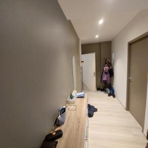 a room with a hallway with shoes on a wooden floor at résidence Les hortensias L4 in Bourbonne-les-Bains