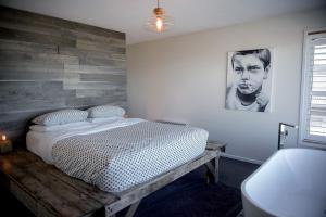 a bedroom with a bed and a wooden wall at Couples Getaway on Bruny Island in Alonnah