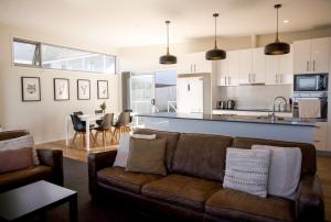 a living room with a couch and a kitchen at Couples Getaway on Bruny Island in Alonnah