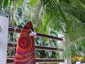 una tabla de surf colorida en un poste junto a una palmera en Dreamcatcher Hotel - Atrapasueños, en Santa Teresa Beach